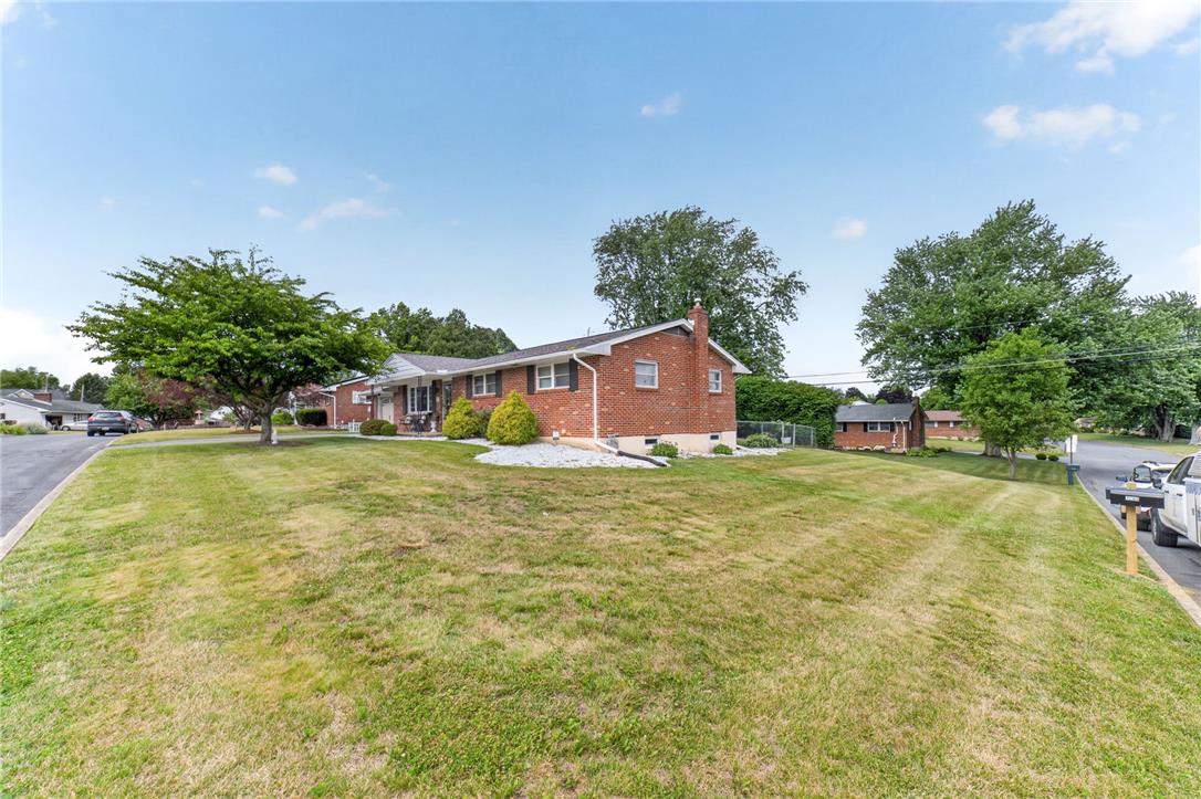 7290 Heather Road Macungie, PA 18062 - Photo 3 of 39 A well-maintained brick residence is surrounded by an ample, verdant yard, offering a welcoming neighborhood appeal.