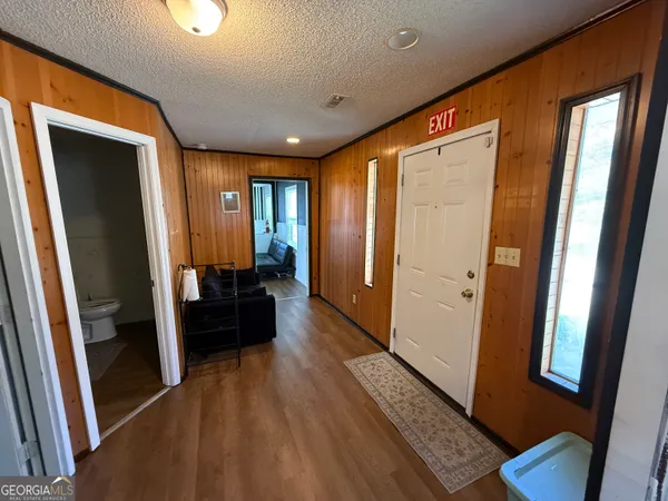 a view of a hallway with wooden floor and furniture
