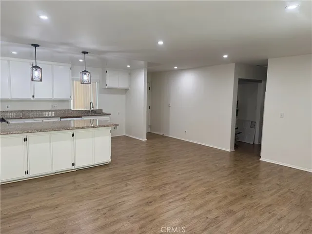 a large kitchen with stainless steel appliances a large counter top a sink and a refrigerator