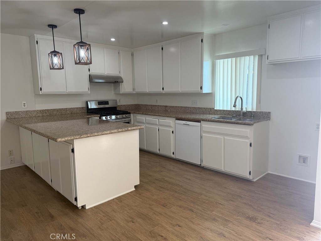 437 Richmond Street, Unit 4 El Segundo, CA 90245 - Photo 3 of 7 a kitchen with kitchen island granite countertop a sink a counter space appliances and cabinets