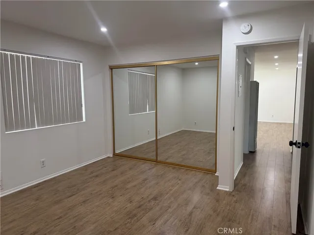 an empty room with wooden floor and mirror