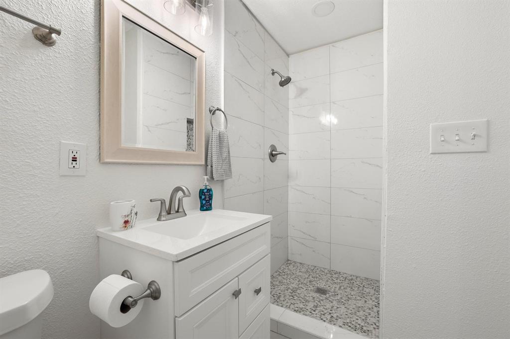 2401 Sunset Street Denison, TX 75020 - Photo 17 of 30 a bathroom with a sink a toilet and shower