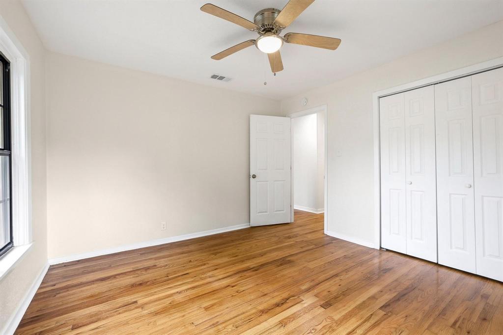 2401 Sunset Street Denison, TX 75020 - Photo 26 of 30 an empty room with wooden floor chandelier fan and closet area