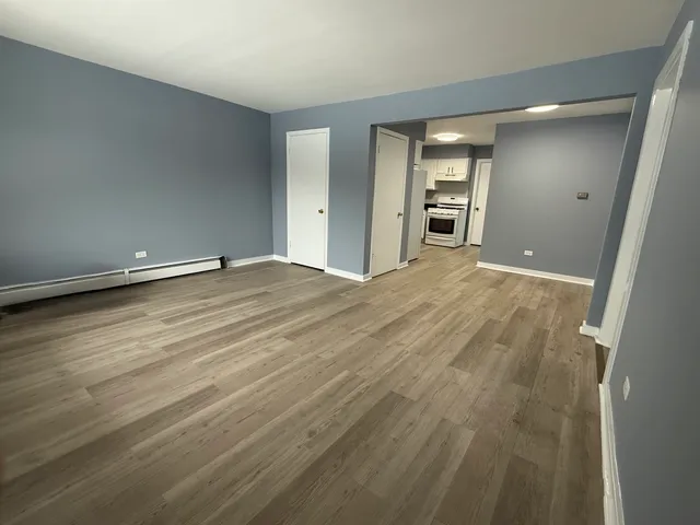 wooden floor in an empty room with a bathroom