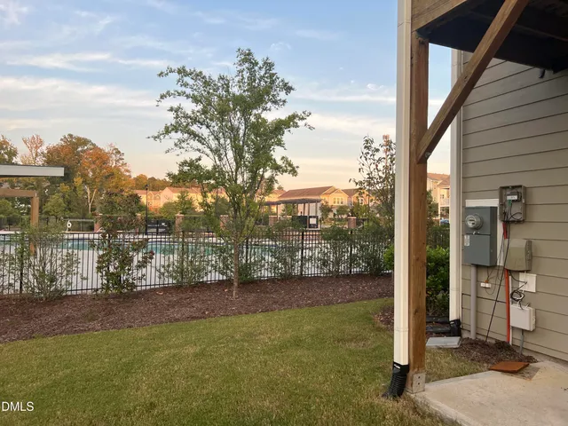 a view of a backyard with table and chairs and wooden fence