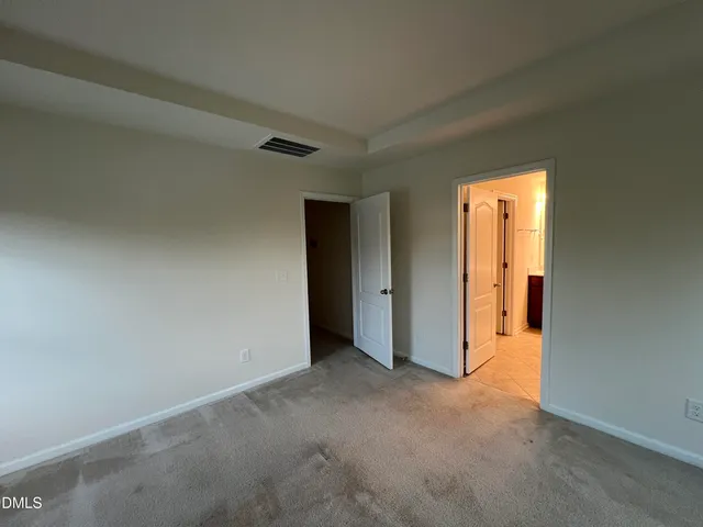 a view of an empty room with window and bathroom