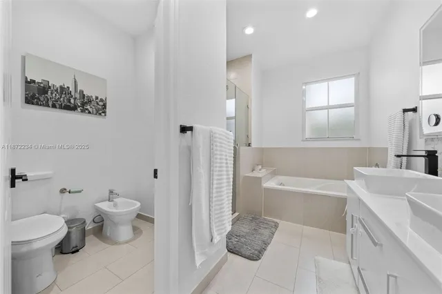 a bathroom with a sink toilet vanity and tub