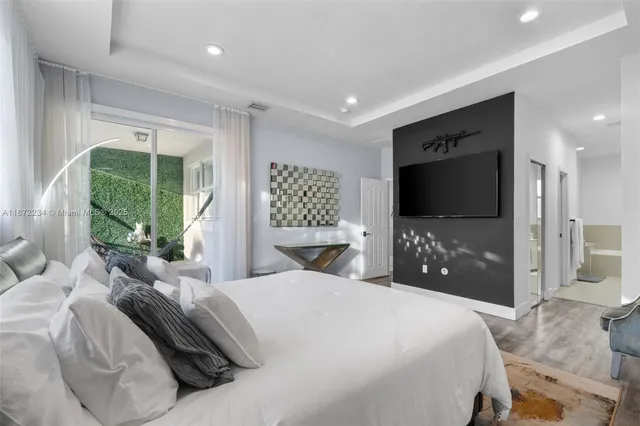 a bedroom with a bed and a flat screen tv