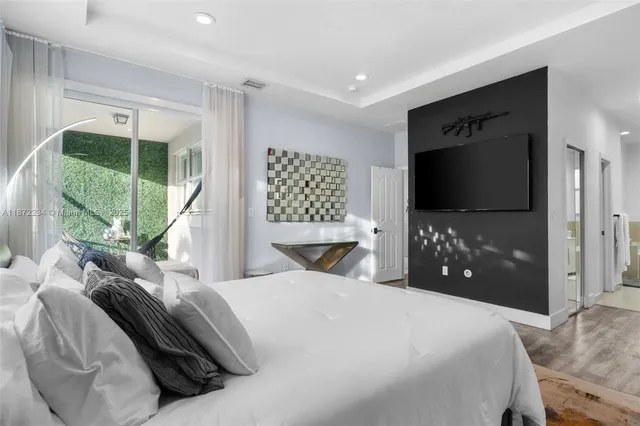 a bedroom with a bed a television and a large window