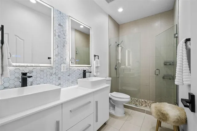 a bathroom with a double vanity sink toilet and shower