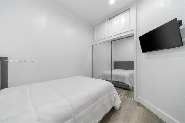 a bedroom with a bed and a flat screen tv