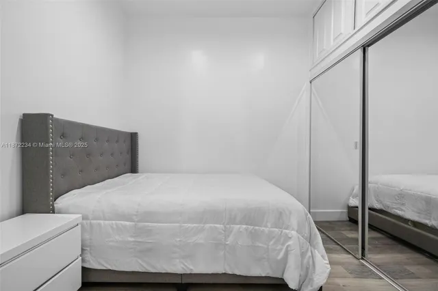 a bedroom with a bed and wooden floor