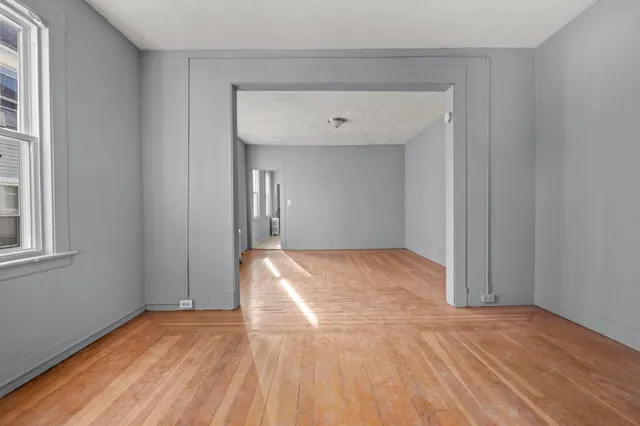 a view of empty room with wooden floor