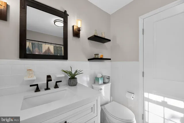 a bathroom with a sink a toilet and mirror