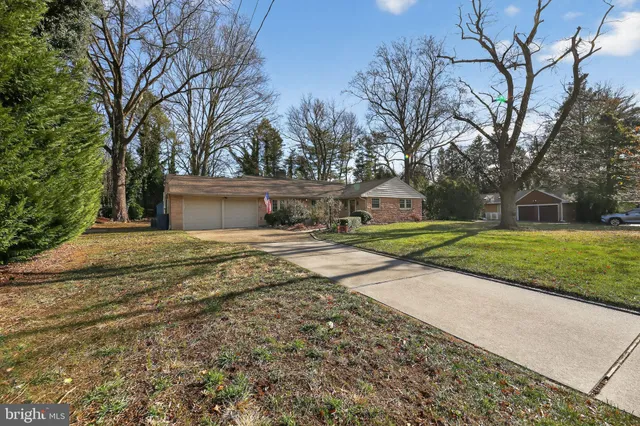 a view of a house with backyard and trees