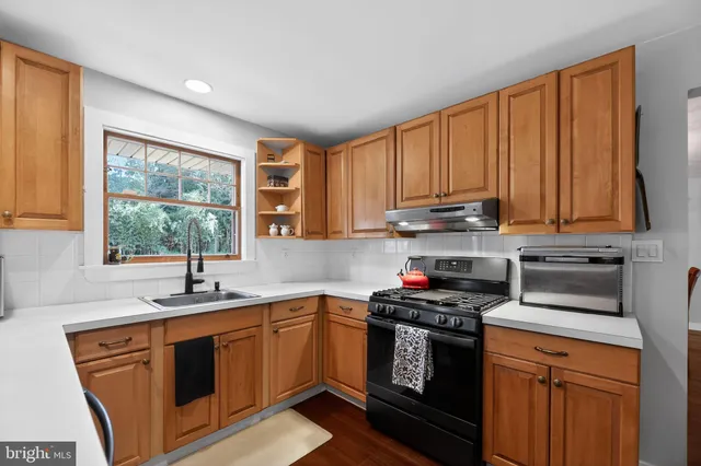 a kitchen with a sink stove top oven and cabinets