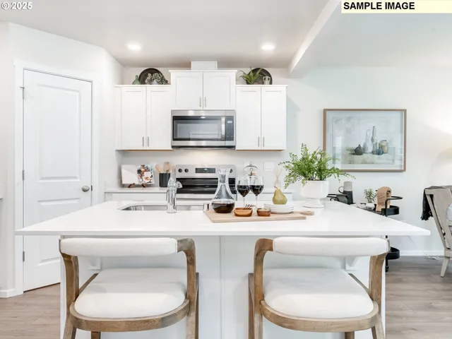 a kitchen with stainless steel appliances a white table and chairs