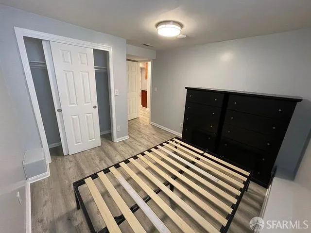 a bedroom with a bed and wooden floor