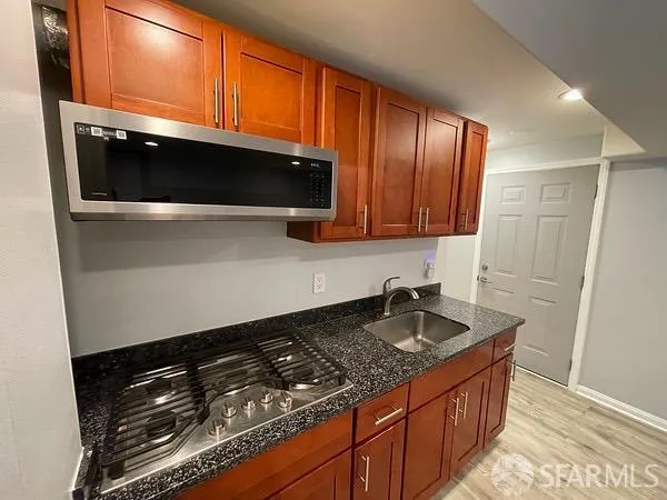 a kitchen with granite countertop stainless steel appliances a sink stove and microwave