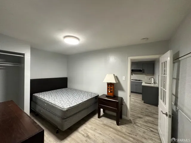 a bedroom with a bed and a view of kitchen