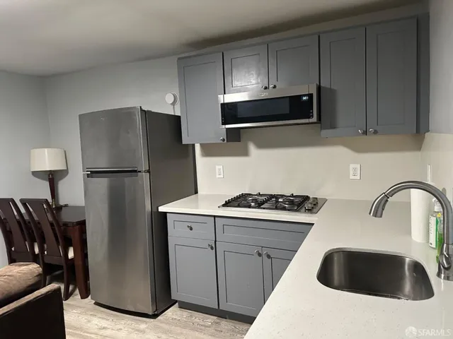 a kitchen with stainless steel appliances granite countertop a refrigerator sink and stove