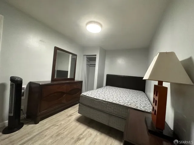 a bedroom with a bed and wooden floor