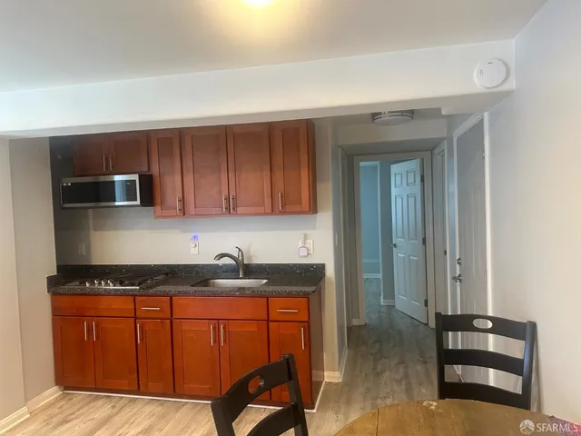 a kitchen with granite countertop wooden cabinets a stove top oven a sink and dishwasher