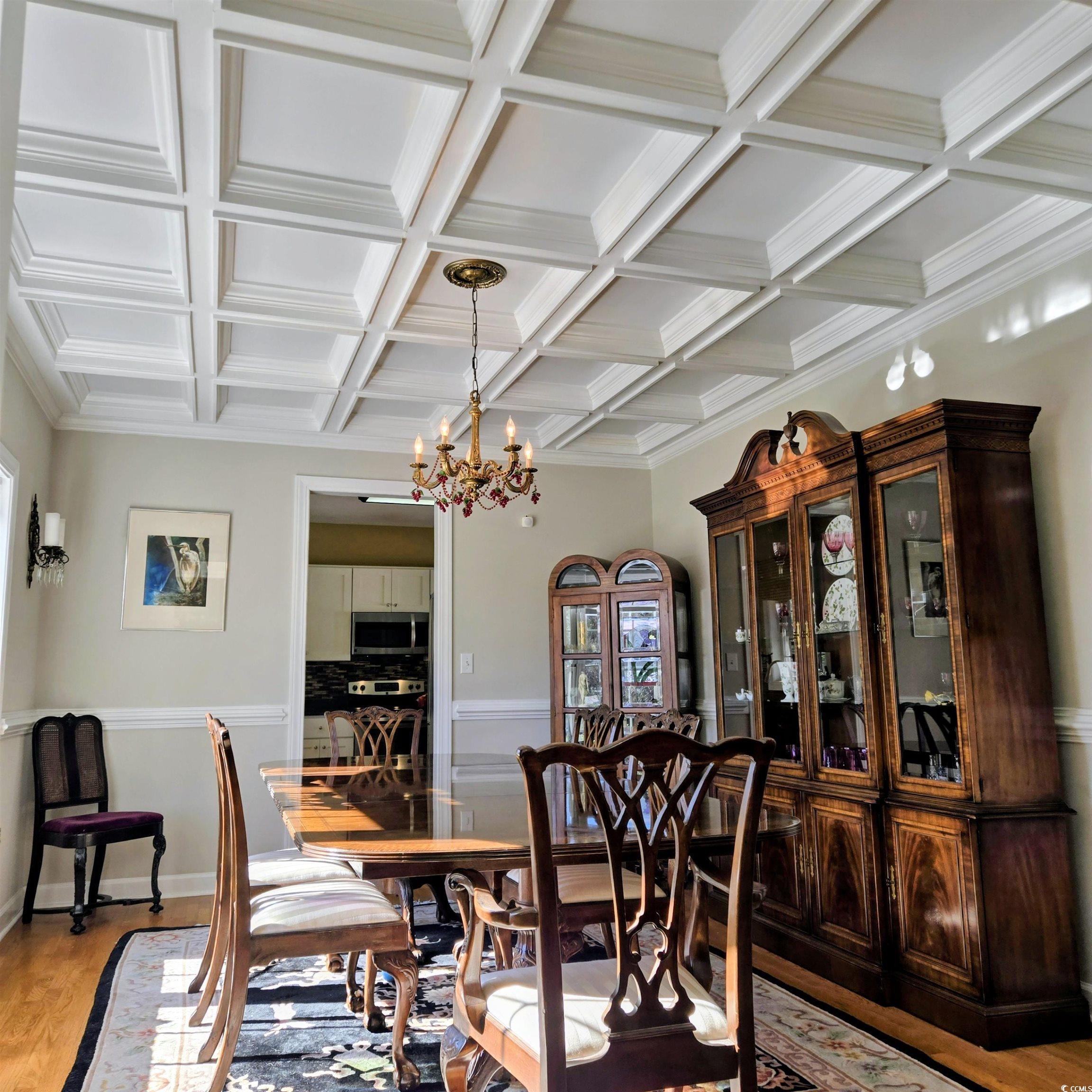 2410 Hunters Trail Myrtle Beach, SC 29588 - Photo 13 of 35 Dining space with coffered ceiling, light wood finished floors, a chandelier, beamed ceiling, and crown molding