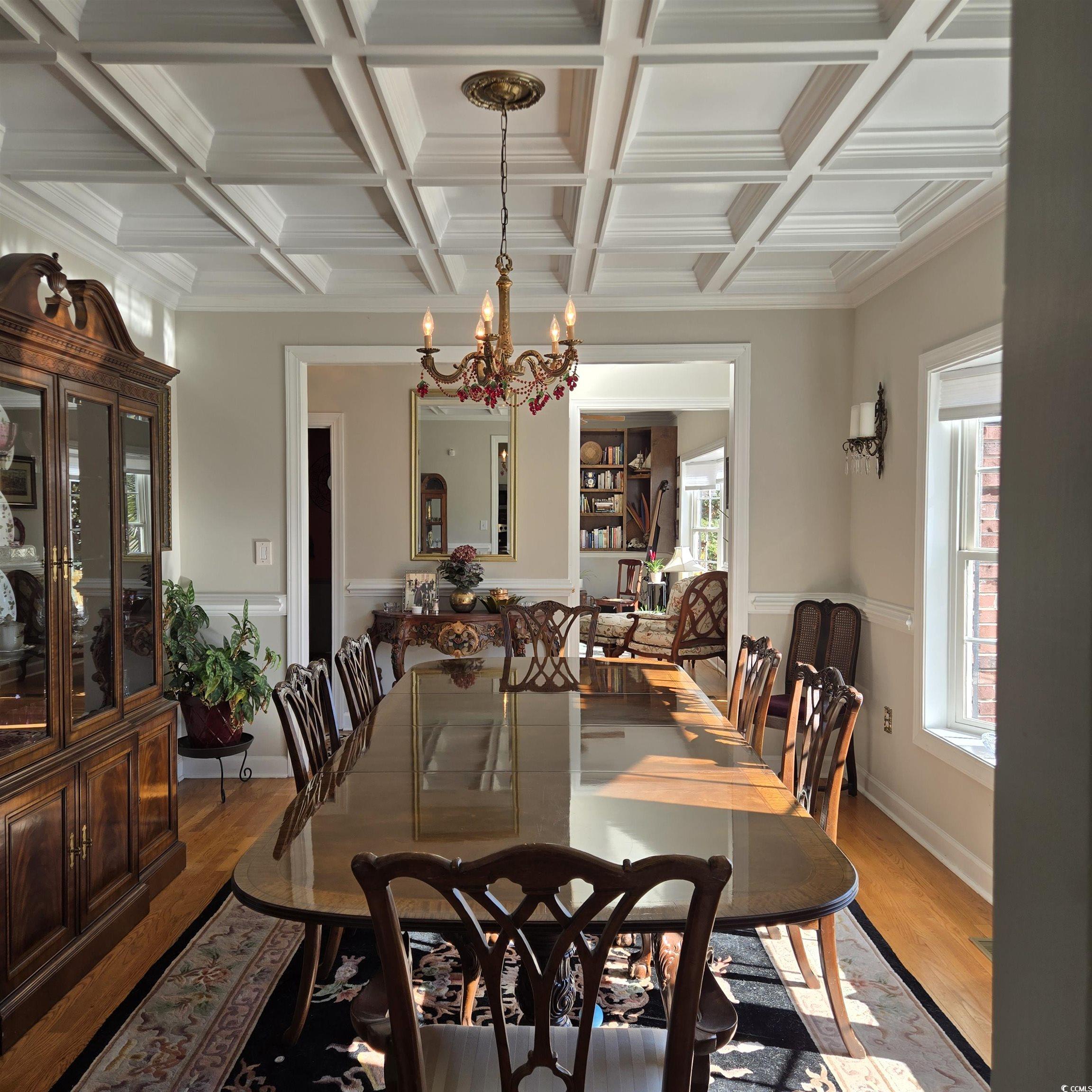 2410 Hunters Trail Myrtle Beach, SC 29588 - Photo 14 of 35 Dining room with a chandelier, ornamental molding, wood finished floors, beamed ceiling, and coffered ceiling
