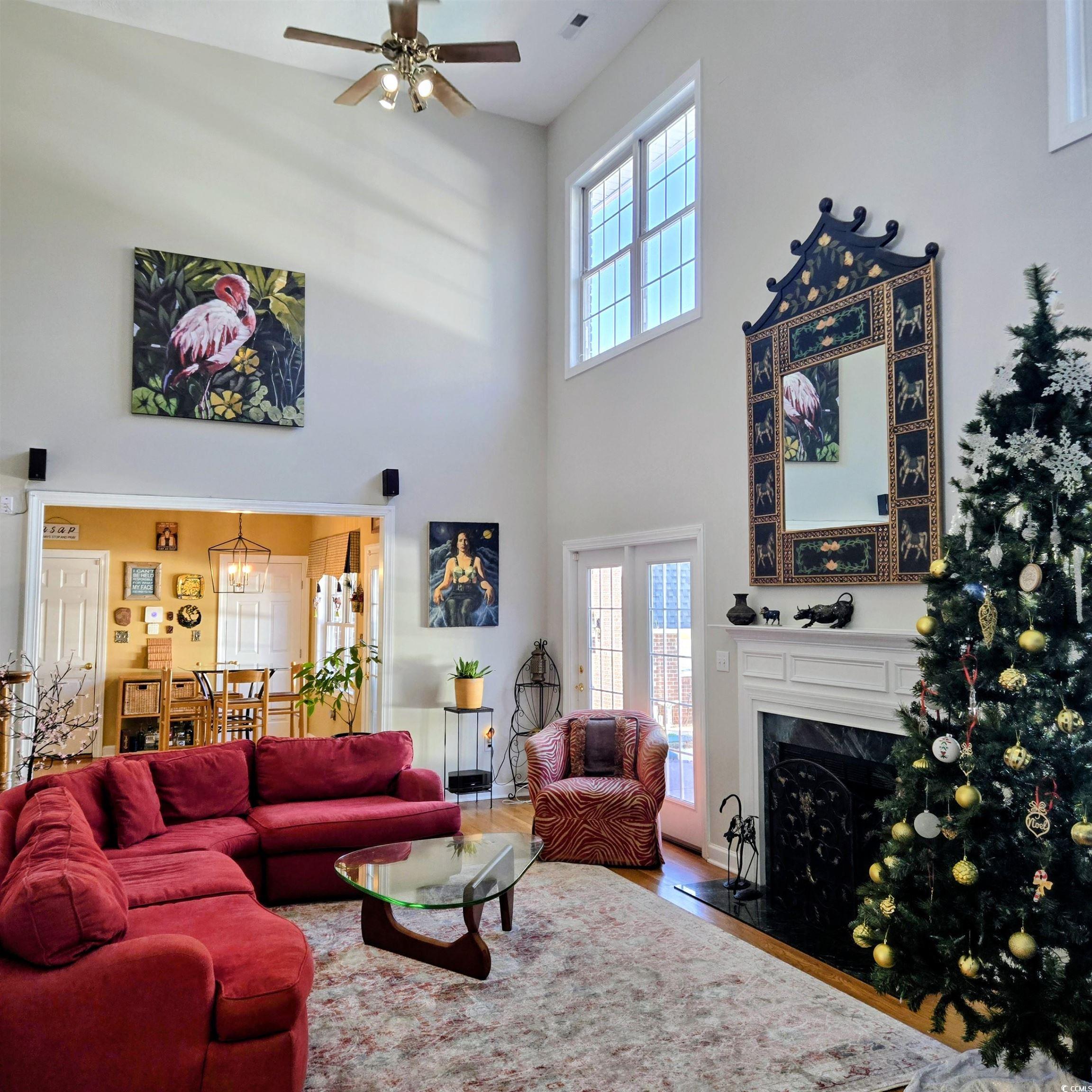 2410 Hunters Trail Myrtle Beach, SC 29588 - Photo 7 of 35 Living area featuring a high ceiling, healthy amount of natural light, a high end fireplace, a chandelier, and wood finished floors