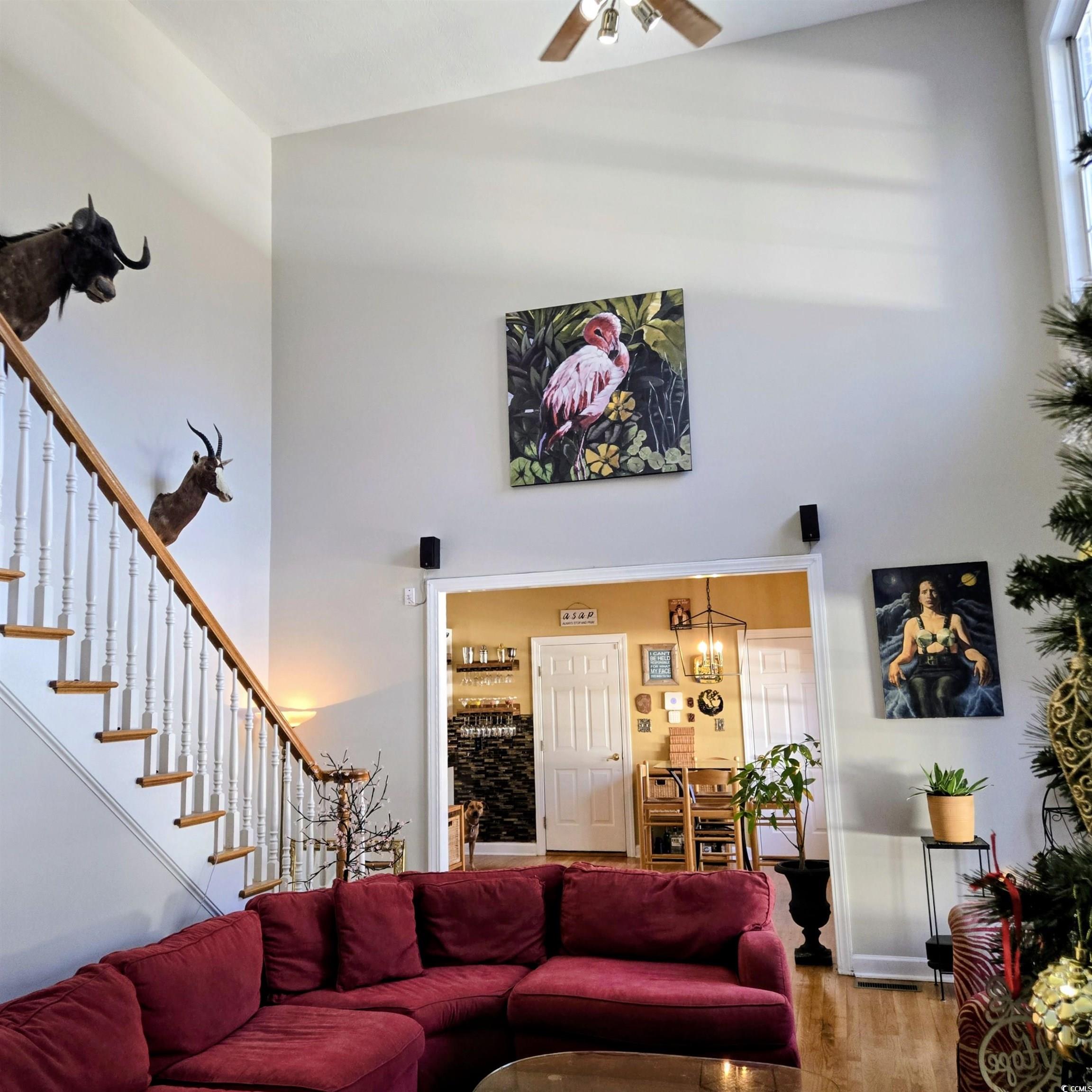 2410 Hunters Trail Myrtle Beach, SC 29588 - Photo 8 of 35 Living area with wood finished floors, stairway, a towering ceiling, and a ceiling fan