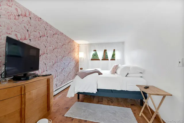 a bedroom with a bed and a flat screen tv