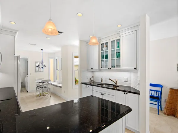 a kitchen with stainless steel appliances granite countertop a sink a stove and a refrigerator