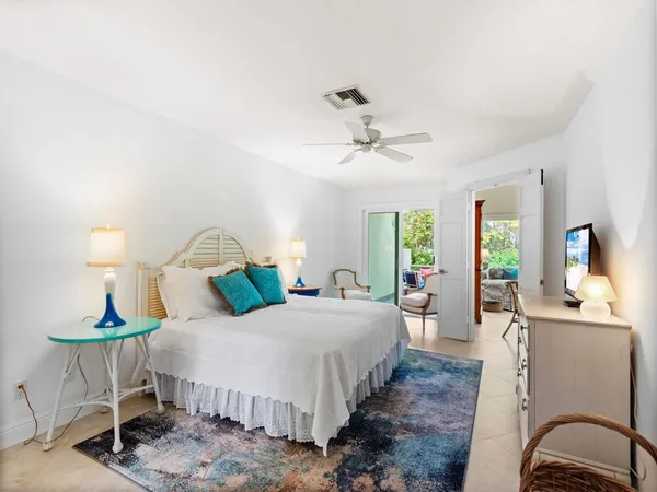 a bedroom with a bed a chandelier and mirror