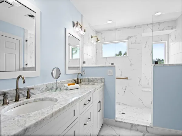 a bathroom with double vanity sinks and a mirror