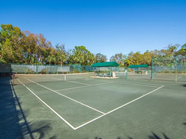 a view of tennis court with trees in the background
