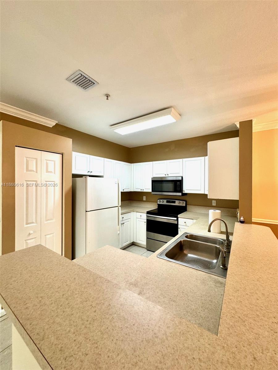 4402 Southwest 160th Avenue, Unit 910 Miramar, FL 33027 - Photo 5 of 22 a kitchen with a refrigerator and a stove top oven