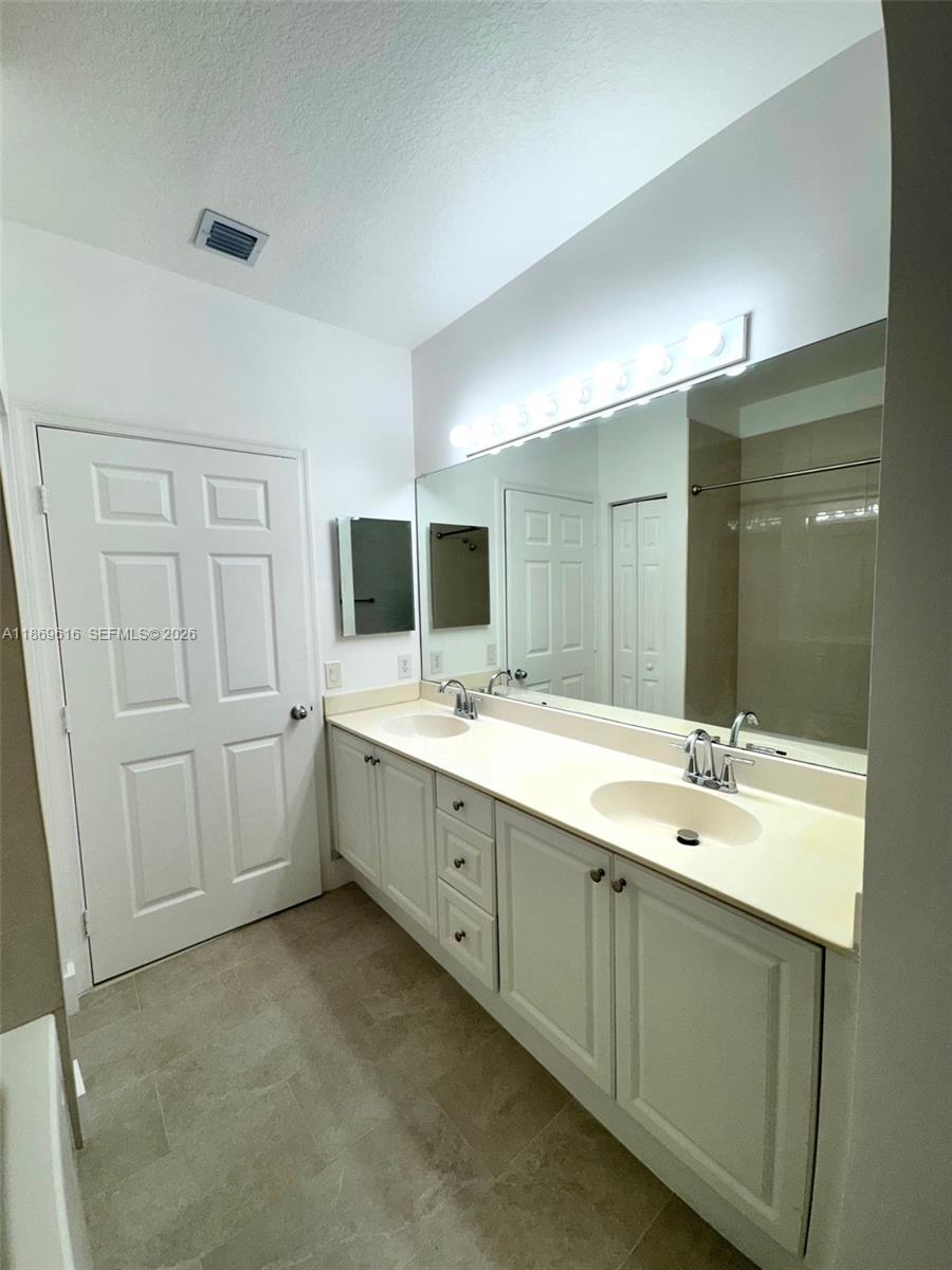 4402 Southwest 160th Avenue, Unit 910 Miramar, FL 33027 - Photo 8 of 22 a bathroom with a double vanity sink and mirror