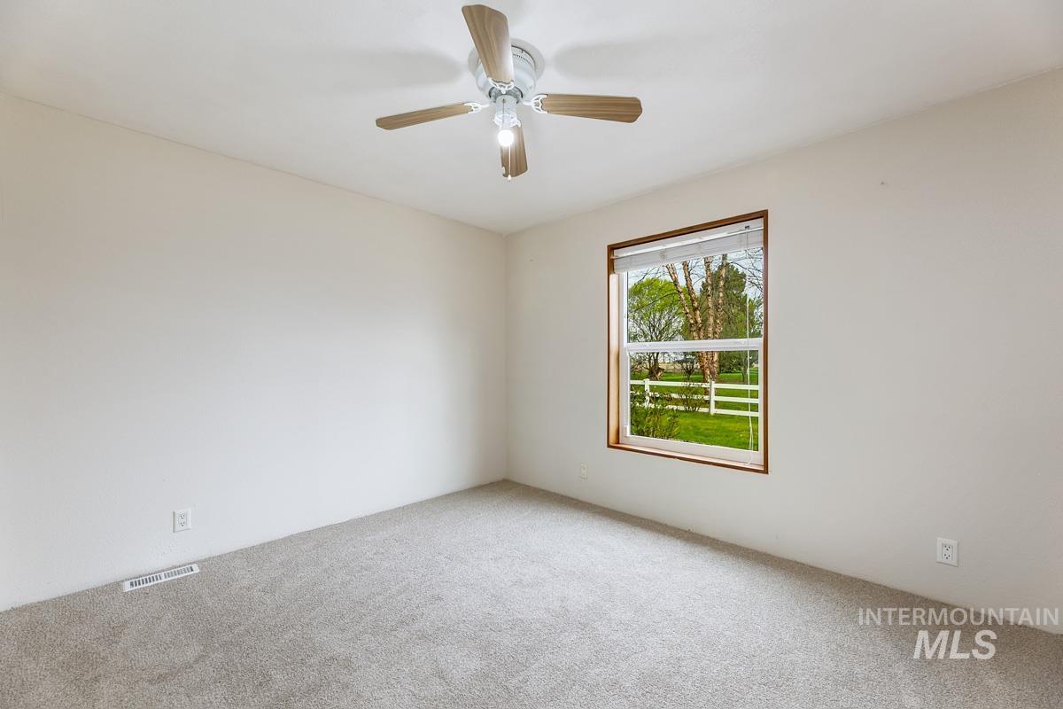 10131 Highway 44 Middleton, ID 83644 - Photo 20 of 42 Empty room featuring light colored carpet and a ceiling fan