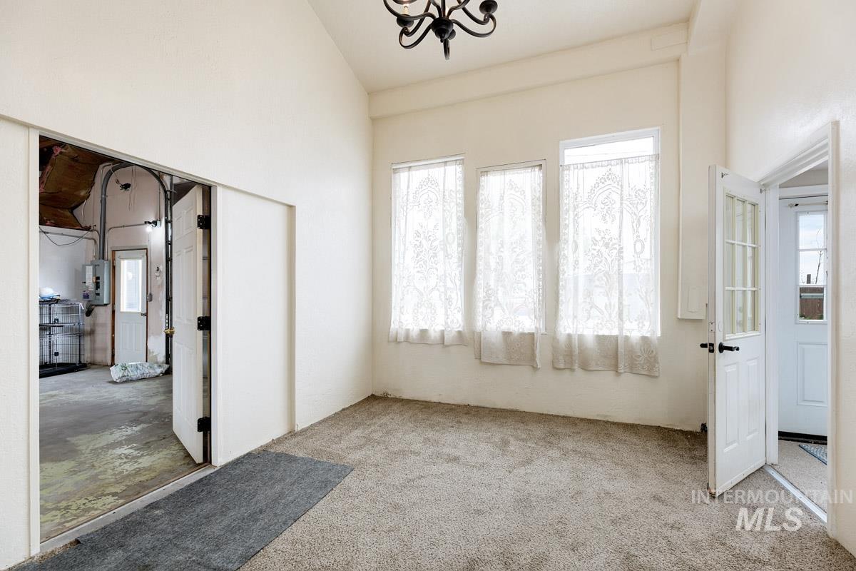 10131 Highway 44 Middleton, ID 83644 - Photo 25 of 42 Spare room featuring lofted ceiling, plenty of natural light, light carpet, and suspended lighting