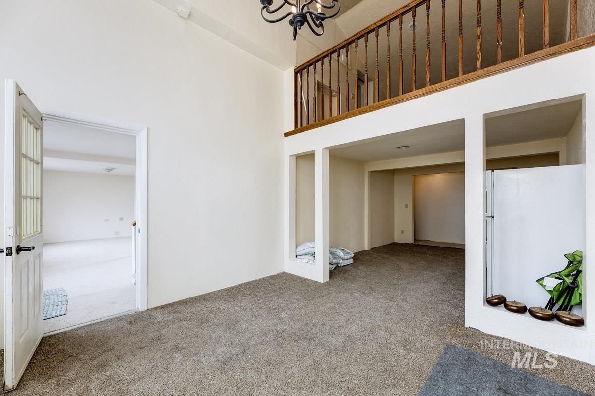 10131 Highway 44 Middleton, ID 83644 - Photo 26 of 42 Unfurnished living room with carpet, a high ceiling, and hanging lights