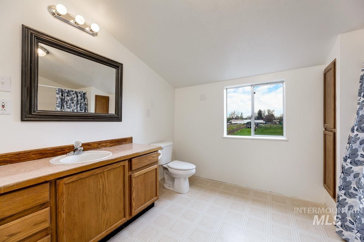 10131 Highway 44 Middleton, ID 83644 - Photo 28 of 42 Bathroom featuring curtained shower, vanity, and vaulted ceiling