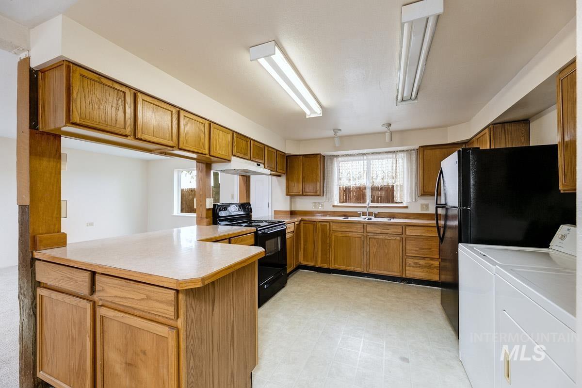 10131 Highway 44 Middleton, ID 83644 - Photo 36 of 42 Kitchen featuring black appliances, light countertops, a peninsula, light flooring, and wood finish cabinets