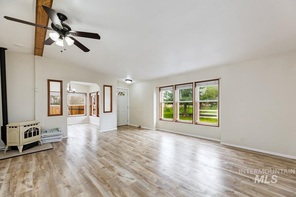 10131 Highway 44 Middleton, ID 83644 - Photo 10 of 42 Unfurnished living room featuring ceiling fan, light wood-type flooring, a wood stove, and lofted ceiling