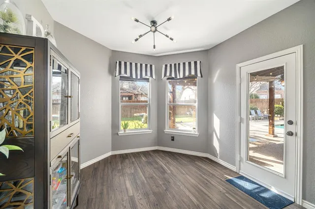 an empty room with windows and chandelier