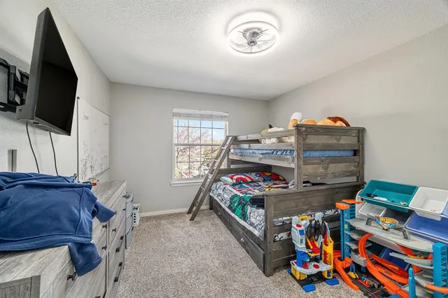 a bedroom with furniture a flat screen tv and a window
