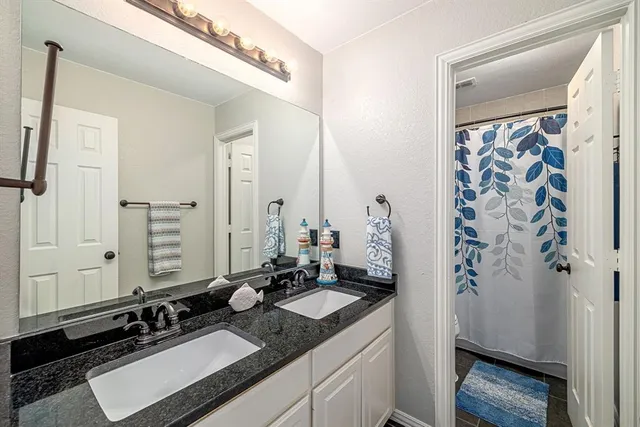 a bathroom with a granite countertop sink and a mirror