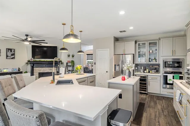 a large kitchen with sink a refrigerator and chairs