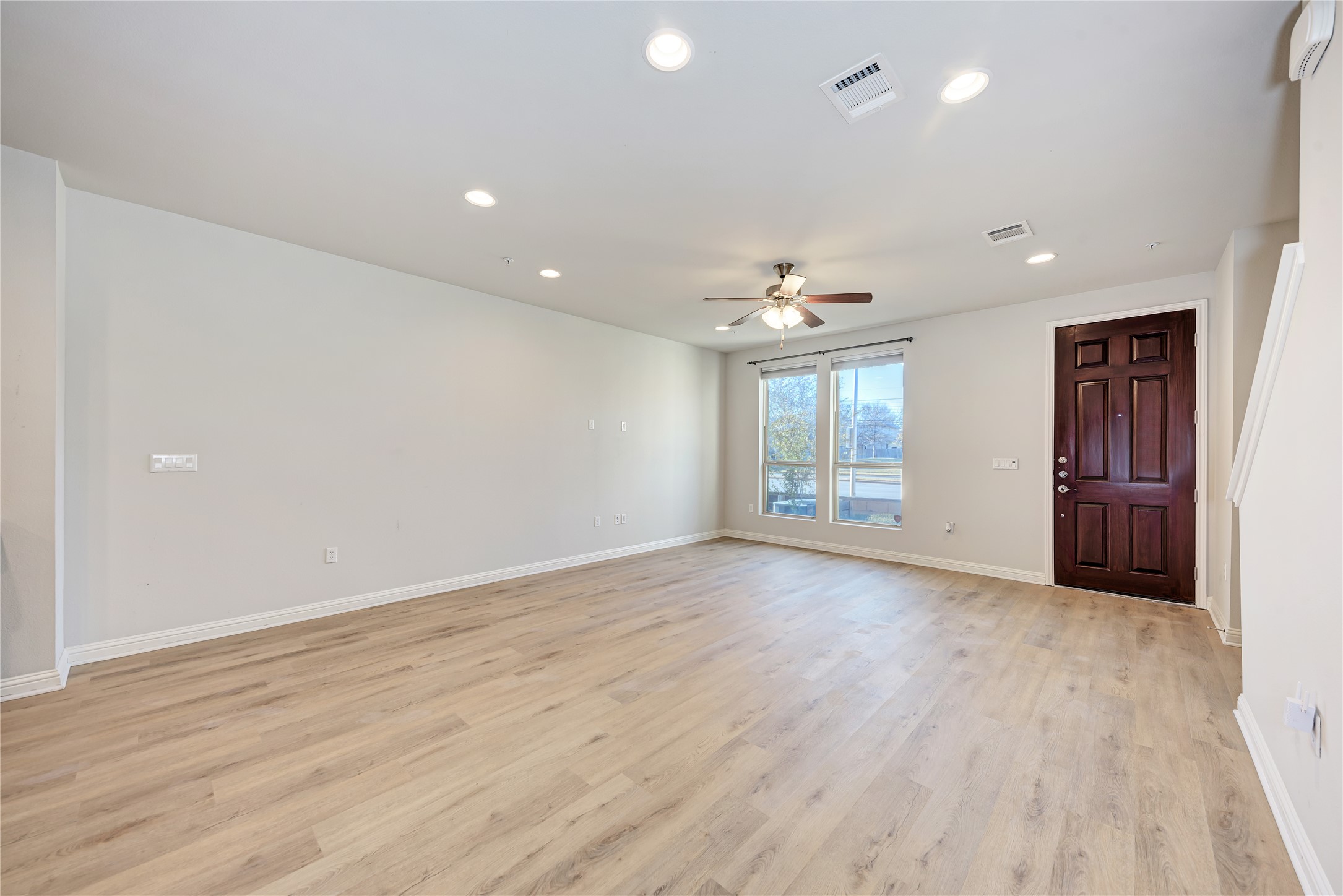6814 East Riverside Drive, Unit 32 Austin, TX 78741 - Photo 3 of 26 an empty room with wooden floor and windows