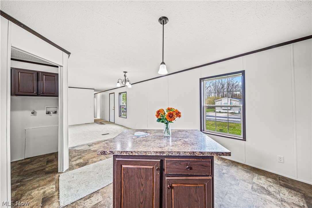 3651 Austin Road, Unit N28 Geneva, OH 44041 - Photo 13 of 30 Kitchen featuring dark tile floors, pendant lighting, dark brown cabinets, and a center island
